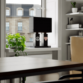 Stand By Me 50cm Negro lámpara de mesa De By Rydéns - La amplia pantalla de tela negra contrasta con las columnas m&aacute;s estrechas de la base de la l&aacute;mpara, ambas decoradas con un s&iacute;mbolo de metal, un signo de la paz en un lado y un coraz&oacute;n en el otro.
