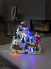 Decoración Navideña Mecánica Con Paisaje Montañoso 28cm Multicolor De Konstsmide - La escena de la monta&ntilde;a cubierta de nieve se ilumina con hermosas luces LED, detalles en movimiento y reproduce 8 canciones navide&ntilde;as cl&aacute;sicas.