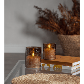 LED Vela Flamme Leaf Marrón De Star Trading - Flamme Leaf es una linterna de cristal que funciona a pilas y está hecha de cristal marrón con un dibujo de hojas en relieve alrededor de una vela de cera blanca.