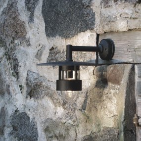 Freja Negro lámpara de exterior De Konstsmide - La lámpara difunde una luz agradable a través de los detalles de vidrio y tiene una pantalla ancha que la protege de los elementos, lo que la hace duradera y funcional.