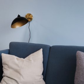 Futura 43cm Latón lámpara de pared De Dyberg Larsen - Está hecho de metal con un exterior negro y un interior de latón, lo que le da un aspecto elegante.