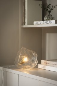 Valerie 22cm Transparente lámpara de mesa De Globen Lighting - El vidrio soplado a mano, con su superficie texturizada, captura la luz, creando un vibrante juego de luces.