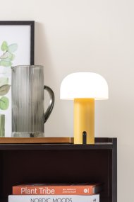 Luca LED 22cm Amarillo portátil De Leitmotiv - Está fabricada en metal con un cálido acabado amarillo y cuenta con una pantalla de plástico blanco lechoso que emite una luz suave y agradable.