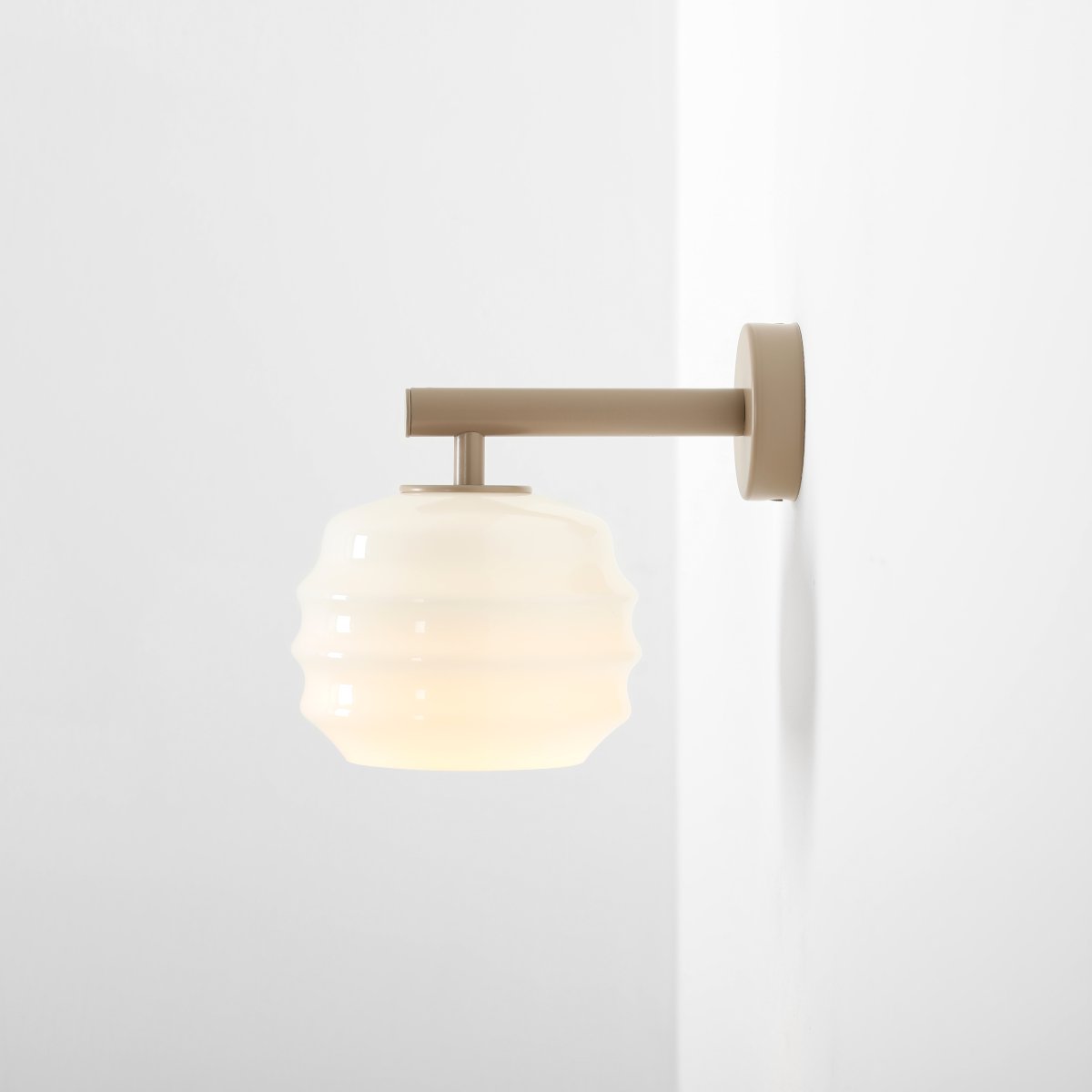 Puff 23cm Beige lámpara de pared De Artera - Su pantalla decorativa de cristal opalino blanco destaca por su forma curva, que le confiere un aspecto a la vez divertido y sofisticado.