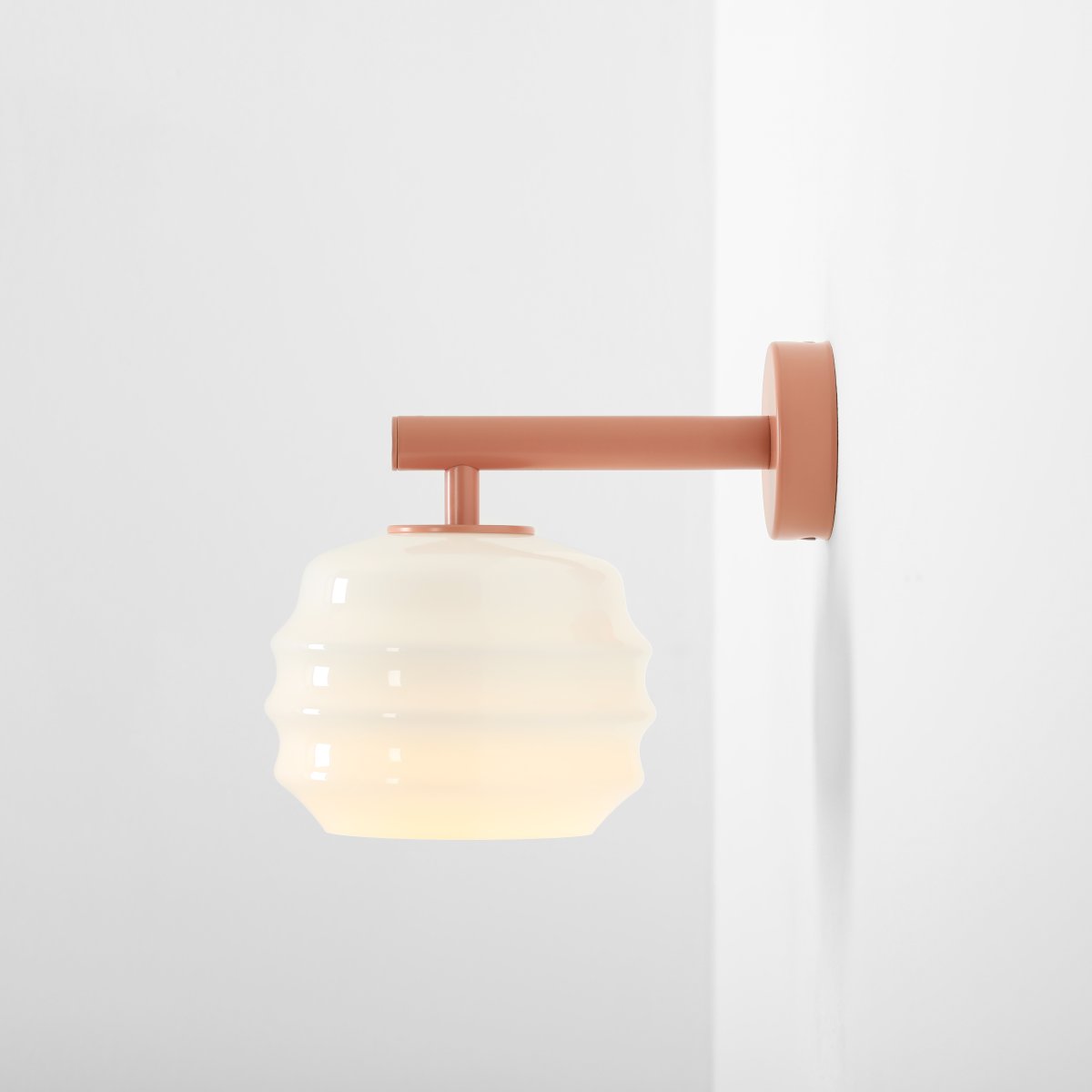 Puff 23cm Coral lámpara de pared De Artera - Su pantalla decorativa de cristal opalino blanco cautiva con su forma curva, otorgándole un aspecto a la vez divertido y sofisticado.