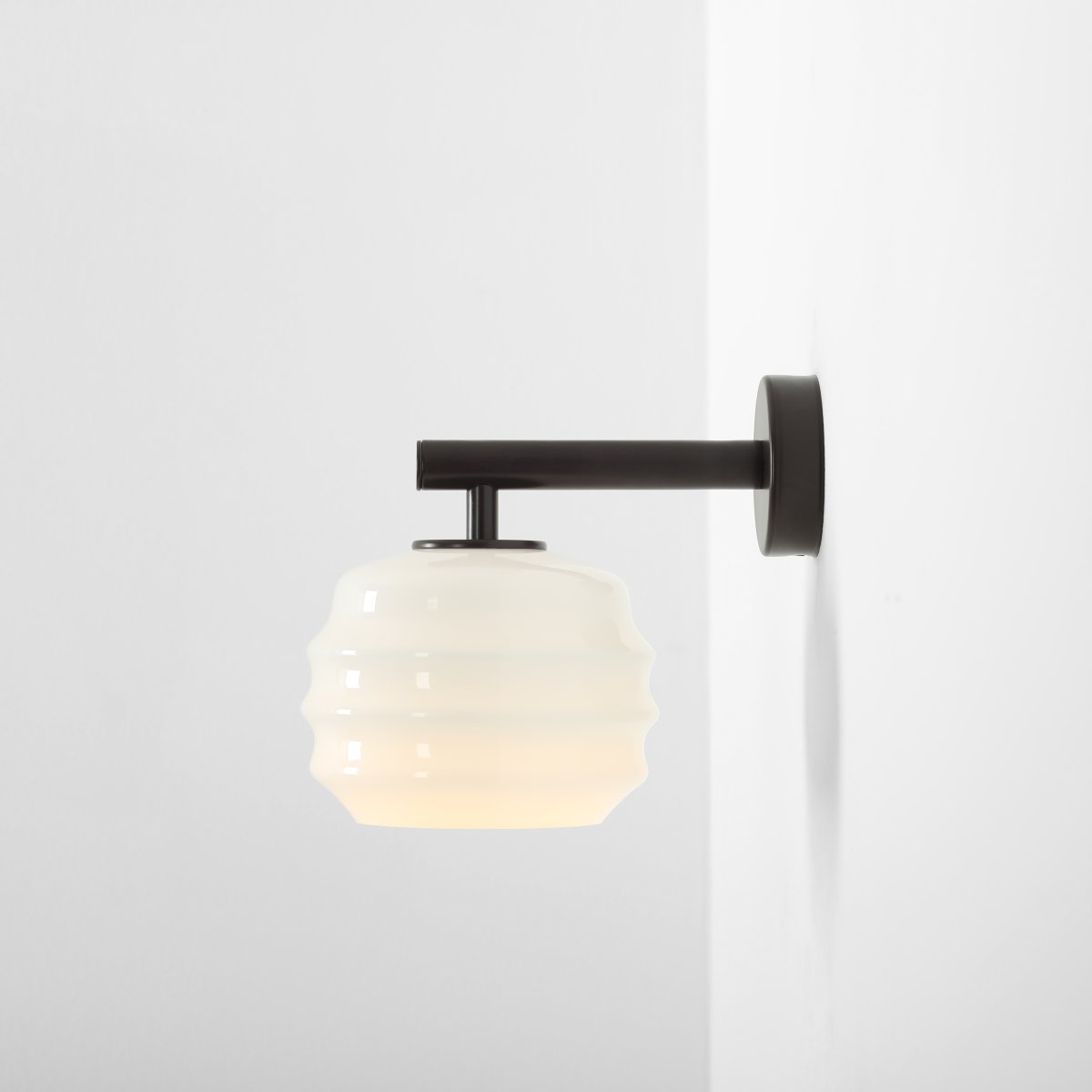 Puff 23cm Marrón oscuro lámpara de pared De Artera - La pantalla decorativa de cristal opalino blanco destaca por su forma curva, que le confiere un aspecto a la vez divertido y sofisticado.