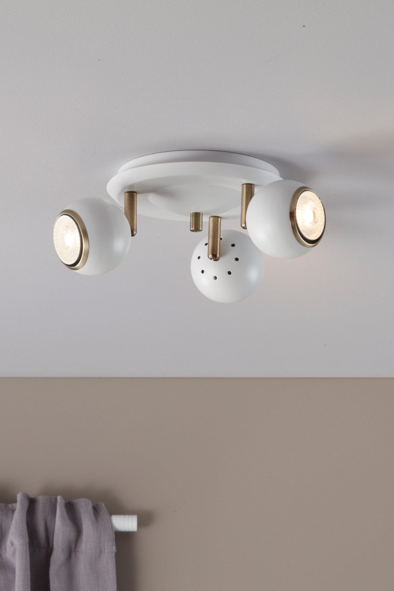 Coco 3 Blanco foco de techo De Markslöjd - Los cabezales de lámpara redondos y blancos combinados con detalles de metal de color antiguo crean una expresión sofisticada y elegante, perfecta para salas de estar, cocinas o áreas de trabajo.