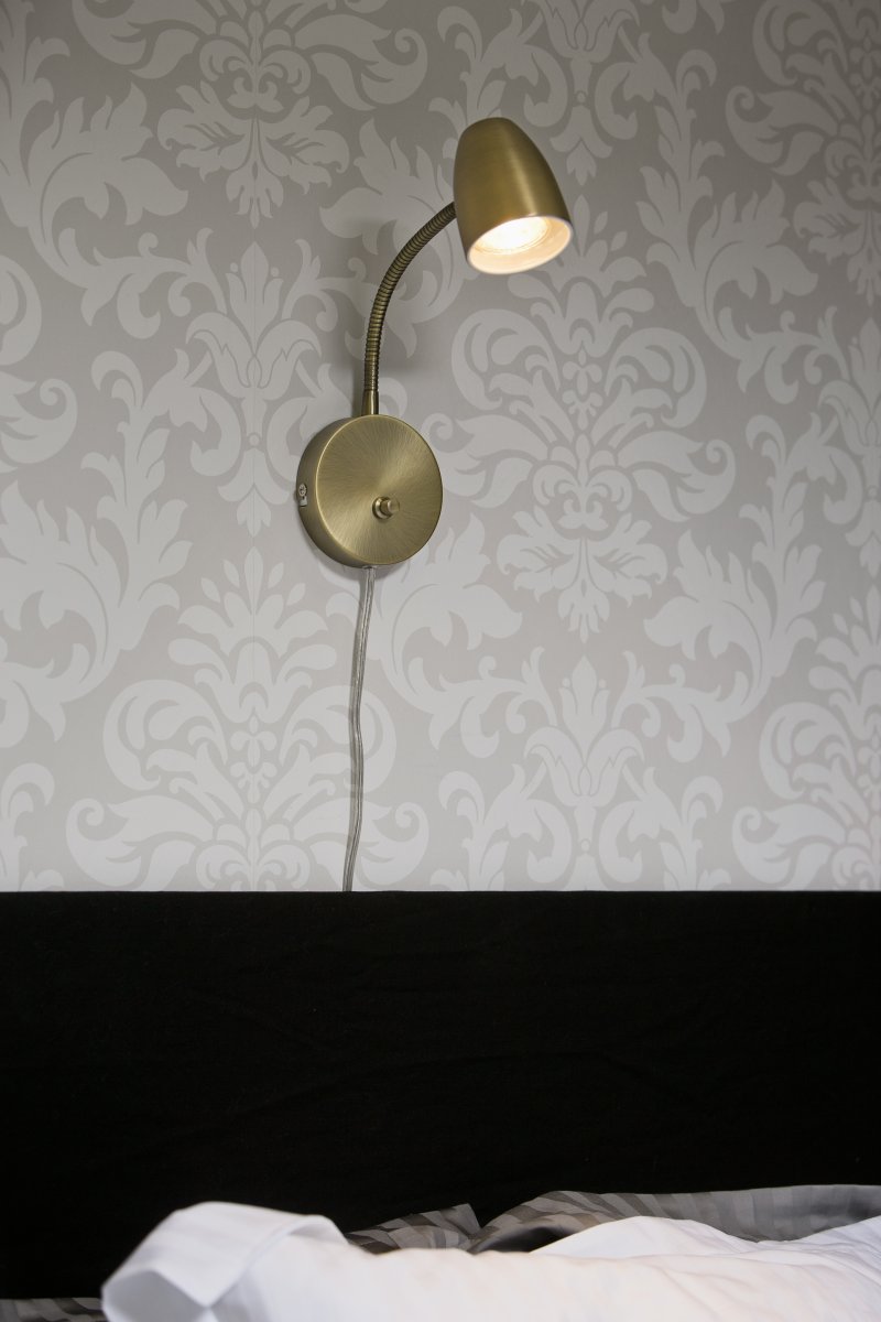 Sandnes Antigüedad lámpara de lectura De Aneta Lighting - Sandnes es la lámpara de noche perfecta, que se puede ajustar fácilmente en ambas direcciones mediante una articulación flexible y el brillo se puede ajustar mediante su regulador de intensidad.