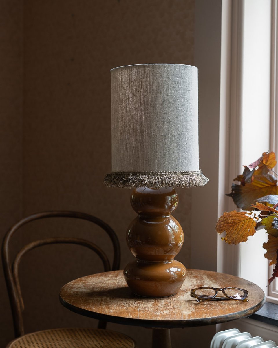 Lampshade Cylinder Fringe Ø22 Naturaleza De Alde & Lind - Los bordes están cuidadosamente doblados y un ribete decorativo de encaje grueso recorre el borde inferior, añadiendo un detalle elegante y exclusivo.