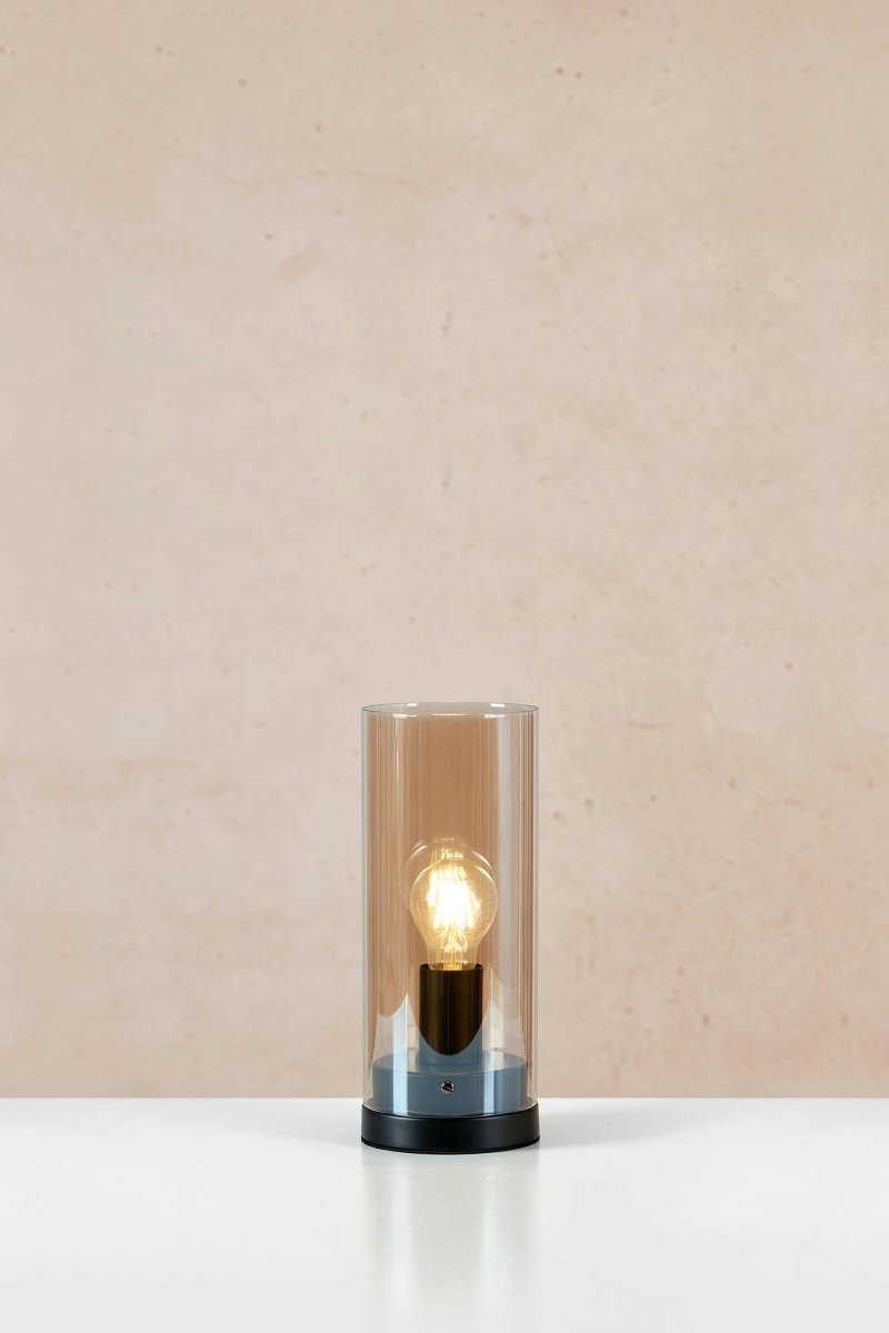 Post 38cm Ámbar lámpara de mesa De Markslöjd - Post es una elegante l&aacute;mpara de mesa cil&iacute;ndrica con una base de metal negro mate y una pantalla de vidrio &aacute;mbar.