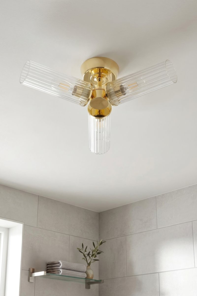 Rimini Ø40 Latón lámpara de baño De Markslöjd - La elegante l&aacute;mpara de techo Rimini combina un acabado de lat&oacute;n pulido con tres pantallas alargadas de cristal transparente estriado.