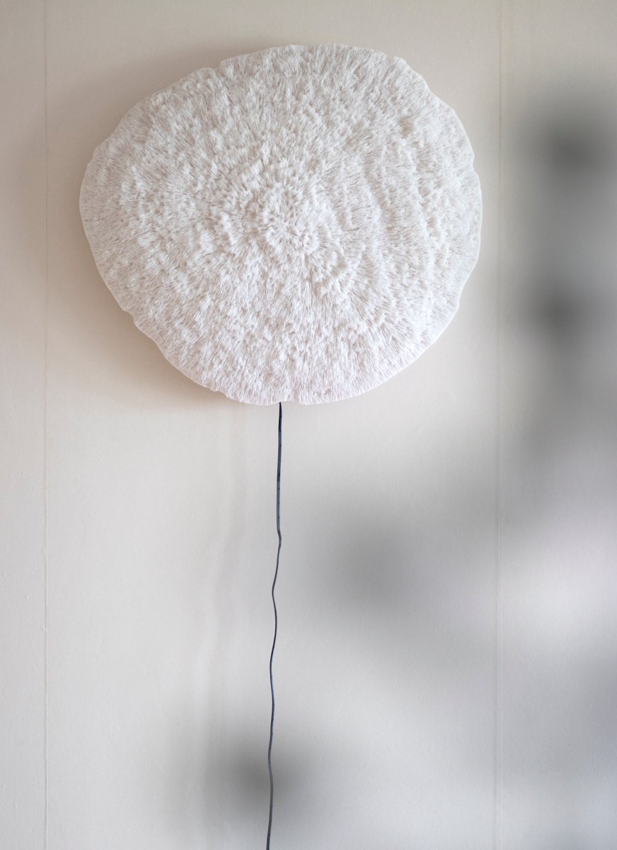 Nemo Blanco lámpara de pared De Globen Lighting - La lámpara está hecha de poliresina blanca y piedra arenisca y tiene un cable negro de 200 cm de largo con interruptor.