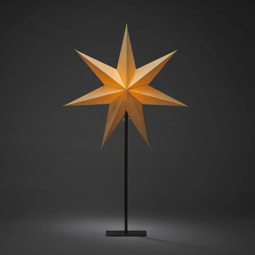 Estrella De Papel Ø50 Beige De Konstsmide - La elegante estrella beige reposa sobre un sencillo soporte de metal negro y emite una luz suave y agradable.