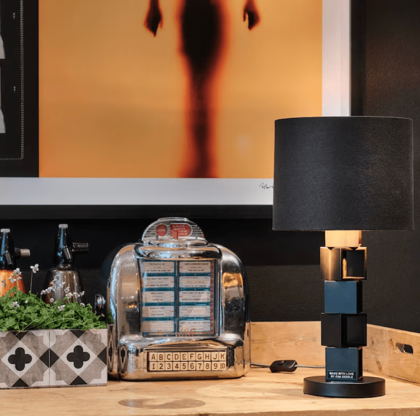 Hello Sunshine 50cm Negro lámpara de mesa De By Rydéns - La pantalla redondeada de tela negra armoniza en contraste con la base de la l&aacute;mpara m&aacute;s estrecha, que consta de bloques apilados uno encima del otro.