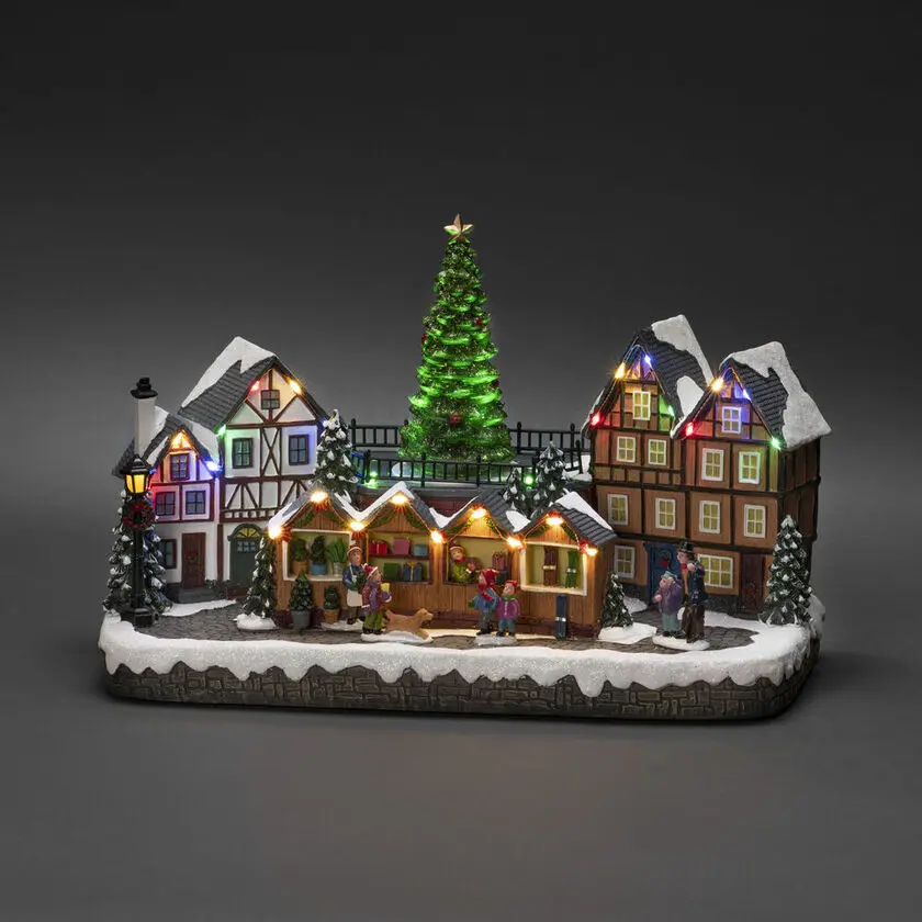 Decoración Navideña Mecánica Con Mercado Navideño 24cm Multicolor De Konstsmide - Con 28 luces LED de color blanco c&aacute;lido, casas cubiertas de nieve, puestos de mercado coloridos y un majestuoso &aacute;rbol de Navidad en el centro, difunde luz y m&uacute;sica.