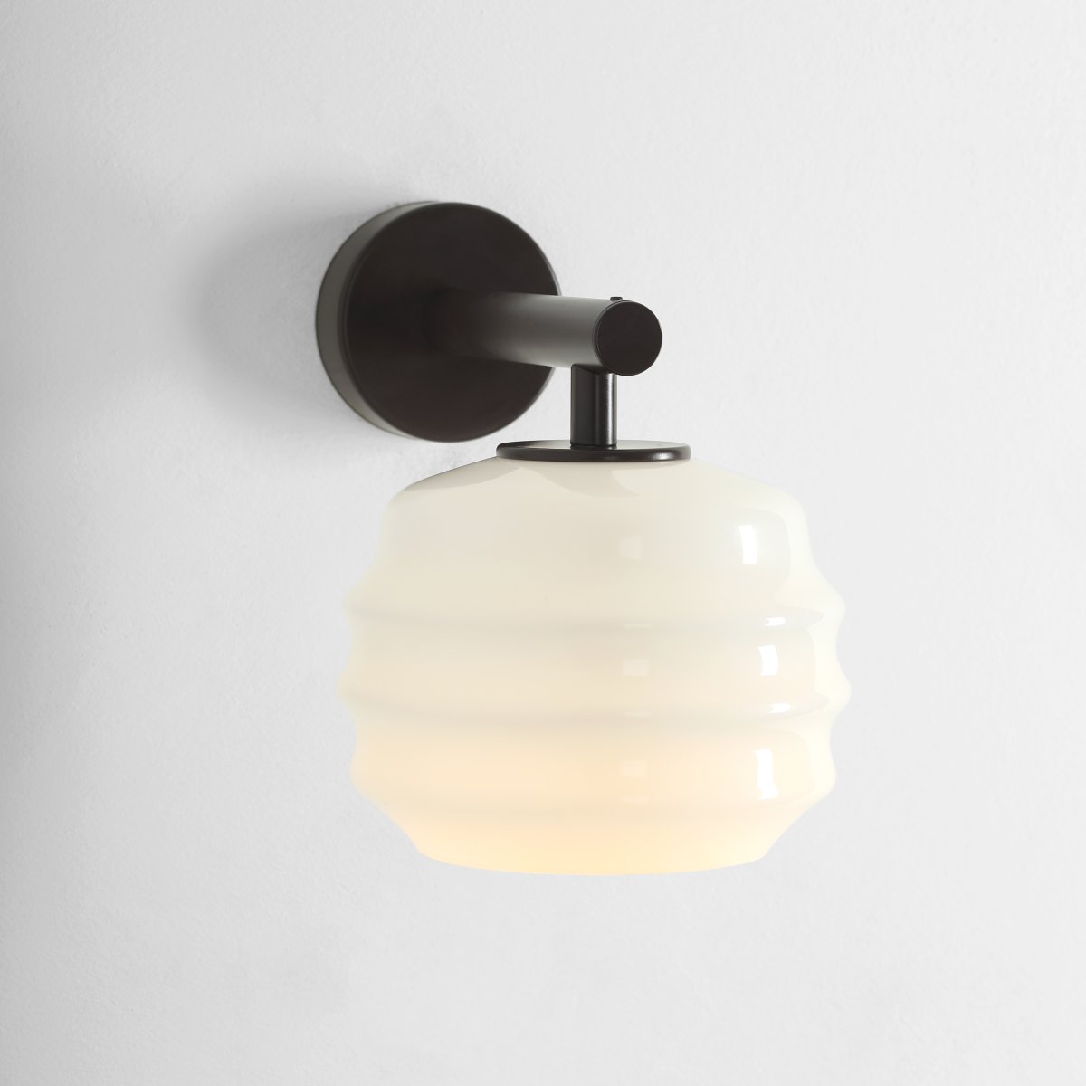 Puff 23cm Marrón oscuro lámpara de pared De Artera - La pantalla decorativa de cristal opalino blanco destaca por su forma curva, que le confiere un aspecto a la vez divertido y sofisticado.