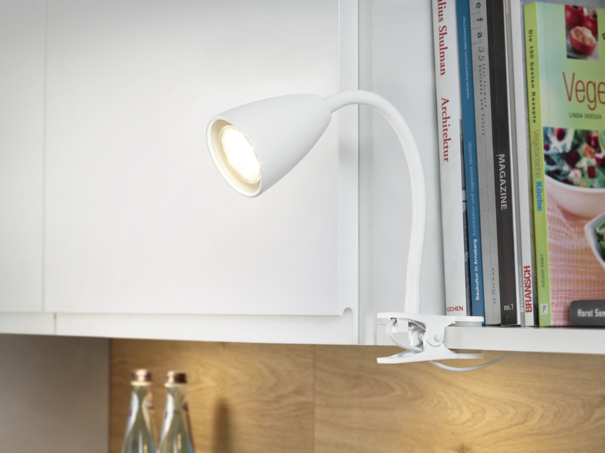 Wanda Blanco lámpara de pinza De Trio Lighting - Colocada correctamente en el escritorio o en el estante, la lámpara proporciona una iluminación óptima gracias a las opciones de ajuste flexibles del brazo de la lámpara.