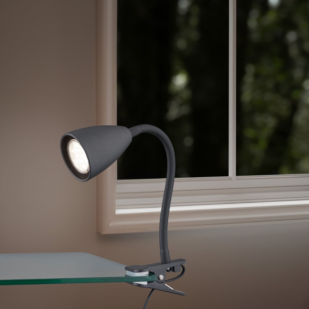 Wanda Negro lámpara de pinza De Trio Lighting - Colocada correctamente en el escritorio o en el estante, la lámpara proporciona una iluminación óptima gracias a las opciones de ajuste flexibles del brazo de la lámpara.