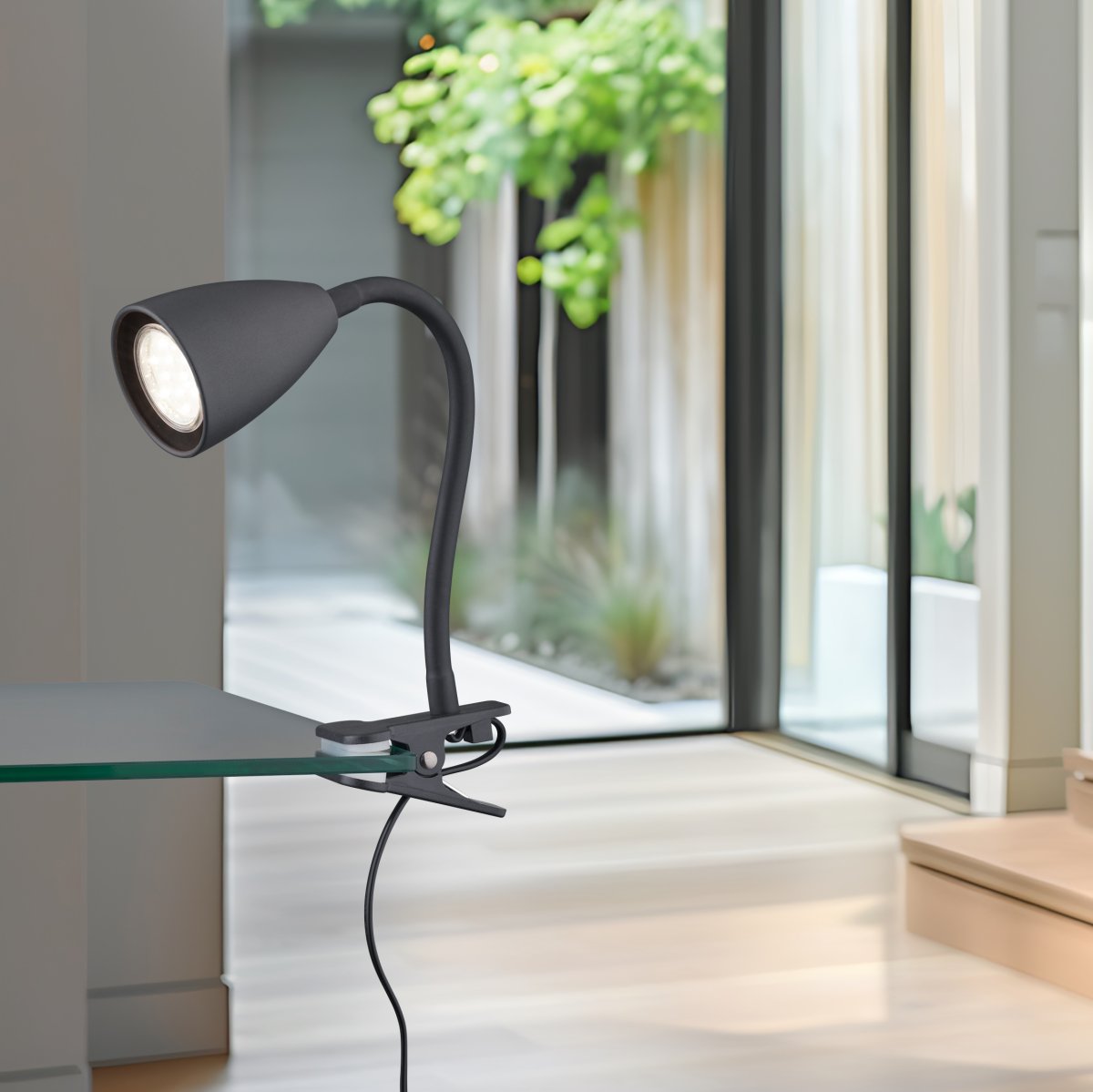 Wanda Negro lámpara de pinza De Trio Lighting - Colocada correctamente en el escritorio o en el estante, la lámpara proporciona una iluminación óptima gracias a las opciones de ajuste flexibles del brazo de la lámpara.