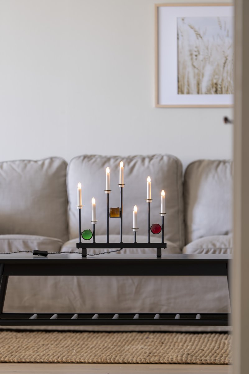 Candelabra 7 Lights Negro De Konstsmide - Las siete velas est&aacute;n enmarcadas por detalles decorativos de vidrio de colores en verde, rojo y &aacute;mbar, creando un ambiente elegante y festivo.