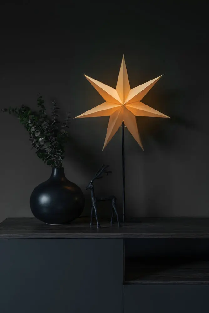 Estrella De Papel Ø50 Beige De Konstsmide - La elegante estrella beige reposa sobre un sencillo soporte de metal negro y emite una luz suave y agradable.