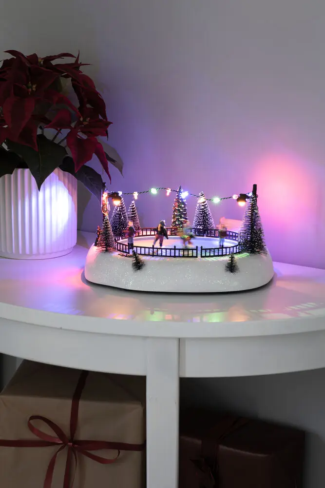 Decoración Navideña Mecánica Con Pista De Patinaje 13cm Multicolor De Konstsmide - Animada pista de patinaje sobre hielo con figuras giratorias, 12 luces LED de colores y m&uacute;sica navide&ntilde;a atmosf&eacute;rica.