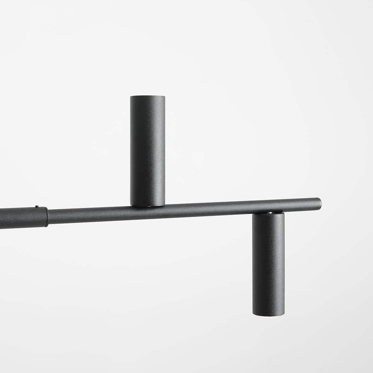 Trevo 145cm Negro Lámpas de techo De Artera - Trevo, con un acabado negro mate, es una lámpara de techo minimalista que distribuye la luz a través de seis fuentes de luz orientadas hacia abajo, mientras que un solo tubo dirige la luz hacia arriba para romper el patrón.