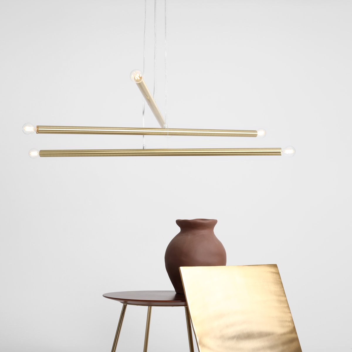 Tubo 6 100cm Latón Lámpas de techo De Artera - Está compuesta por tres tubos metálicos delgados con un elegante acabado en latón, dispuestos a diferentes alturas y ángulos para crear un aspecto dinámico y ligero.