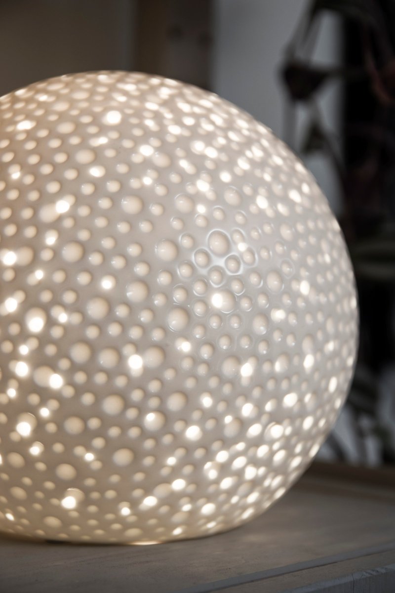 Moonlight 20cm Blanco lámpara de mesa De Globen Lighting - La superficie de esta lámpara de mesa un poco más moderna presenta agujeros perforados de diferentes tamaños, así como cráteres que recuerdan la apariencia de los hombres.