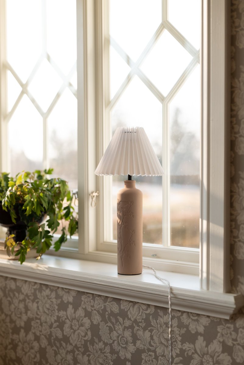 Flora 46cm Lodo lámpara de mesa De Globen Lighting - Como bello detalle, un dibujo de flor de endrino est&aacute; prensado en un lado de la base de la l&aacute;mpara, d&aacute;ndole un verdadero toque de artesan&iacute;a.
