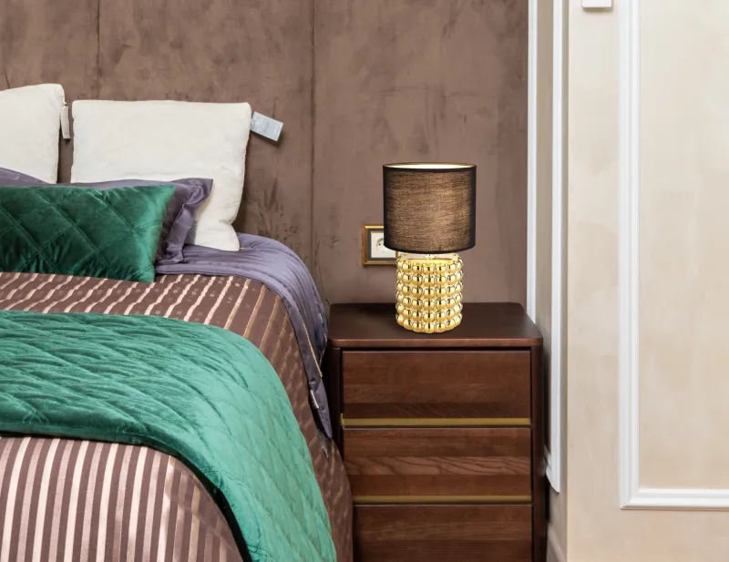 Valentino 33cm Oro lámpara de mesa De Globo Lighting - P&aring; en cylinderformad fot i guldf&auml;rgad keramik vilar en stilren, svart textilsk&auml;rm.