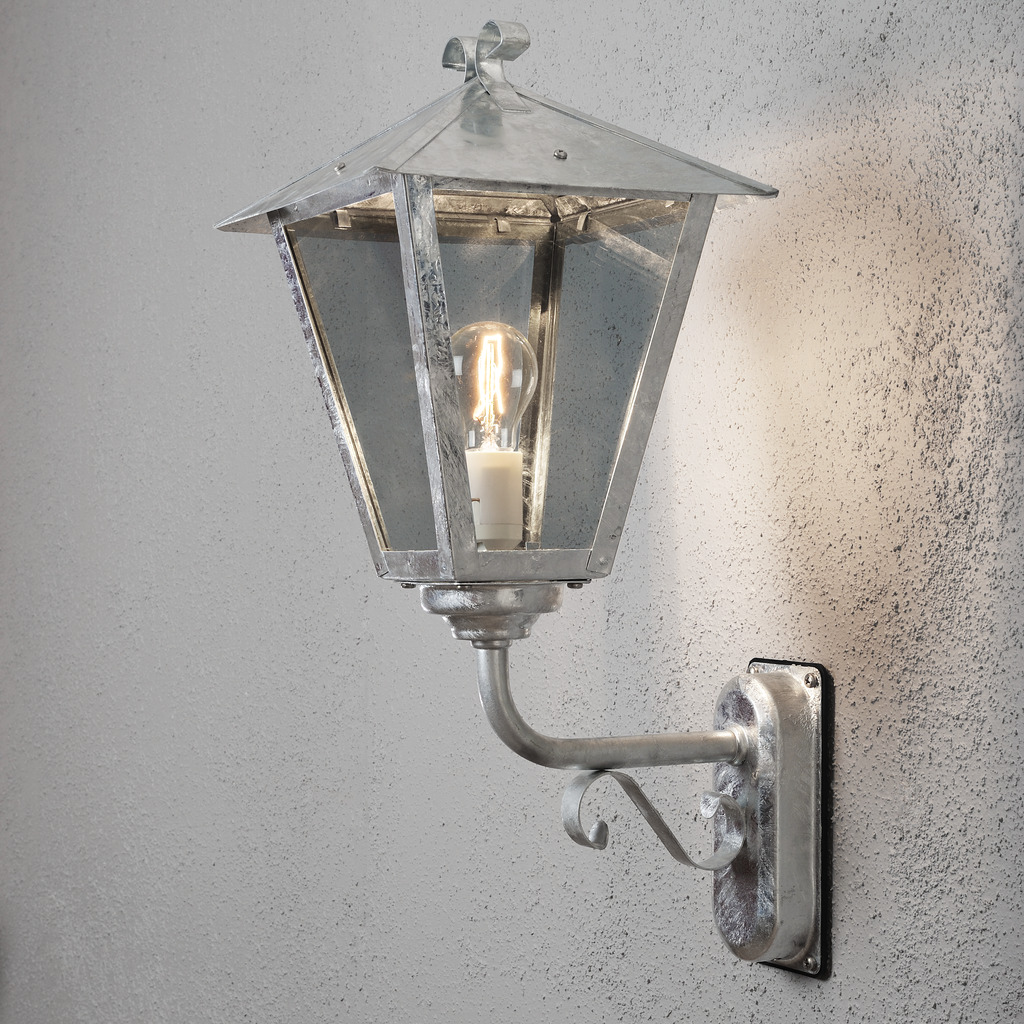 Benu acero galvanizado lámpara de exterior De Konstsmide - La forma cl&aacute;sica de linterna y los materiales robustos hacen de esta l&aacute;mpara la elecci&oacute;n perfecta para cualquiera que quiera crear un ambiente acogedor en zonas de entrada o pasillos largos.