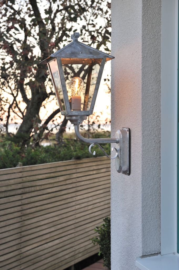 Benu acero galvanizado lámpara de exterior De Konstsmide - La forma cl&aacute;sica de linterna y los materiales robustos hacen de esta l&aacute;mpara la elecci&oacute;n perfecta para cualquiera que quiera crear un ambiente acogedor en zonas de entrada o pasillos largos.
