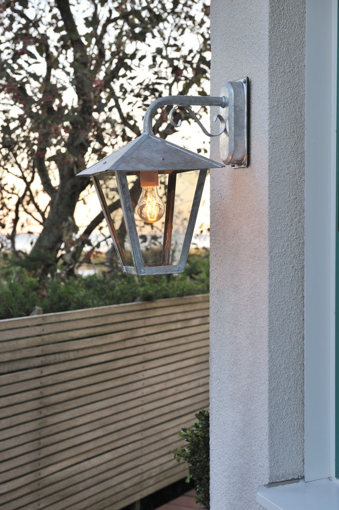 Benu acero galvanizado lámpara de exterior De Konstsmide - La forma cl&aacute;sica de linterna y los materiales robustos hacen de esta l&aacute;mpara la elecci&oacute;n perfecta para cualquiera que quiera crear un ambiente acogedor en zonas de entrada o pasillos largos.