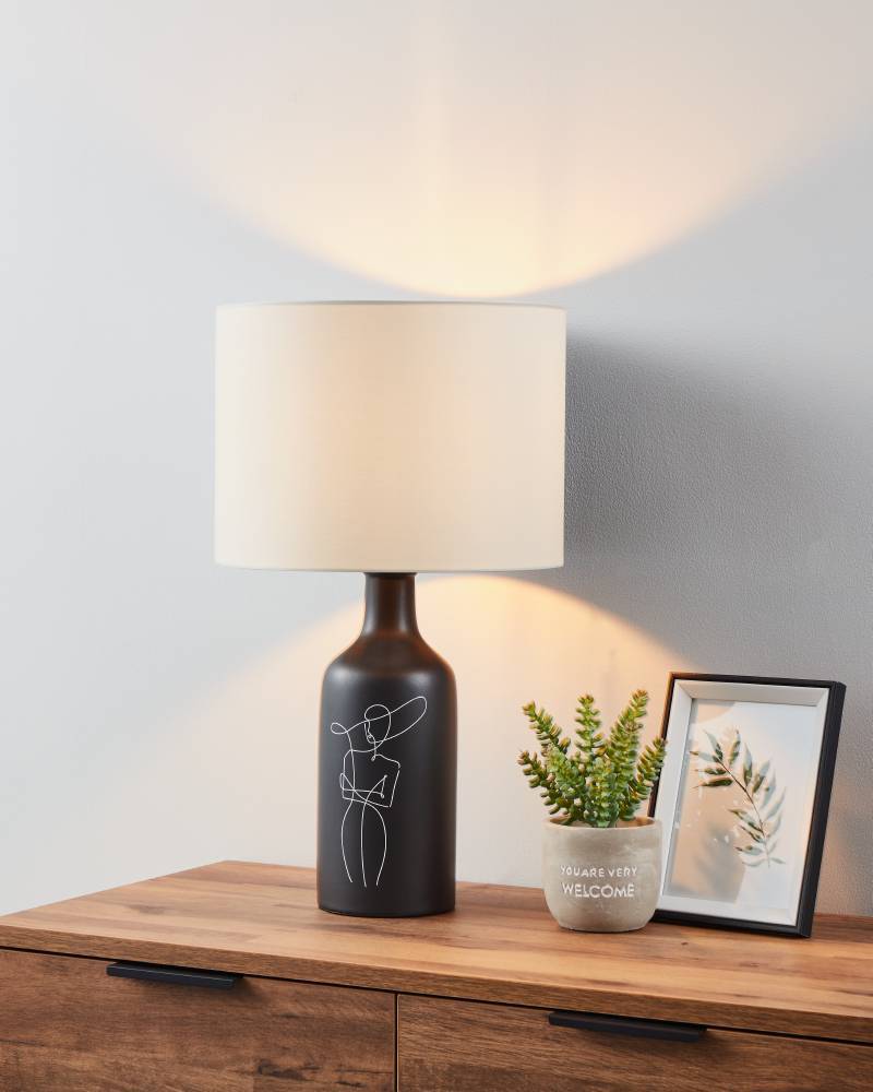 Vinoza 53cm Negro lámpara de mesa De Eglo - Con una base negra decorada con líneas minimalistas que representan a una mujer con sombrero, la lámpara añade un toque sofisticado y artístico a su hogar.