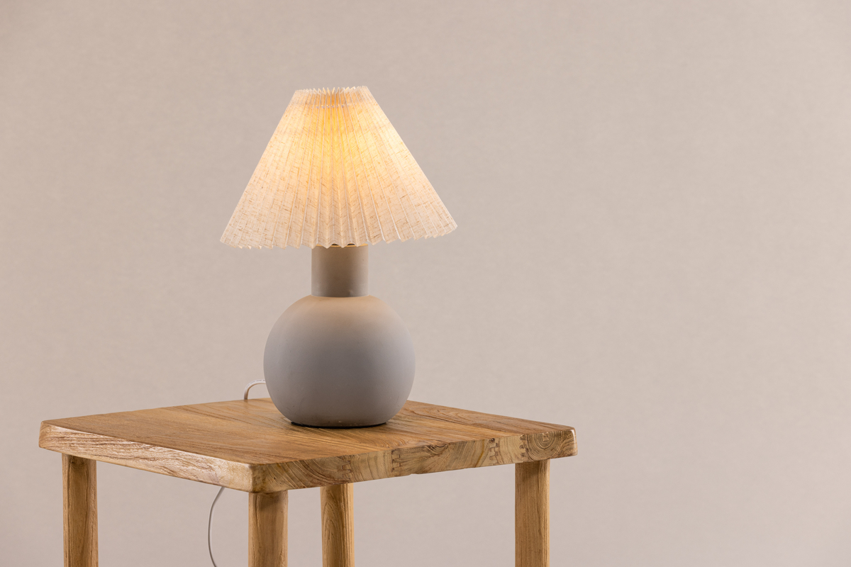 Älvsborg 37cm Gris lámpara de mesa De Venture Design - Hormig&oacute;n, que crea una expresi&oacute;n elegante y r&uacute;stica, y la pantalla de la l&aacute;mpara est&aacute; hecha de lino beige.