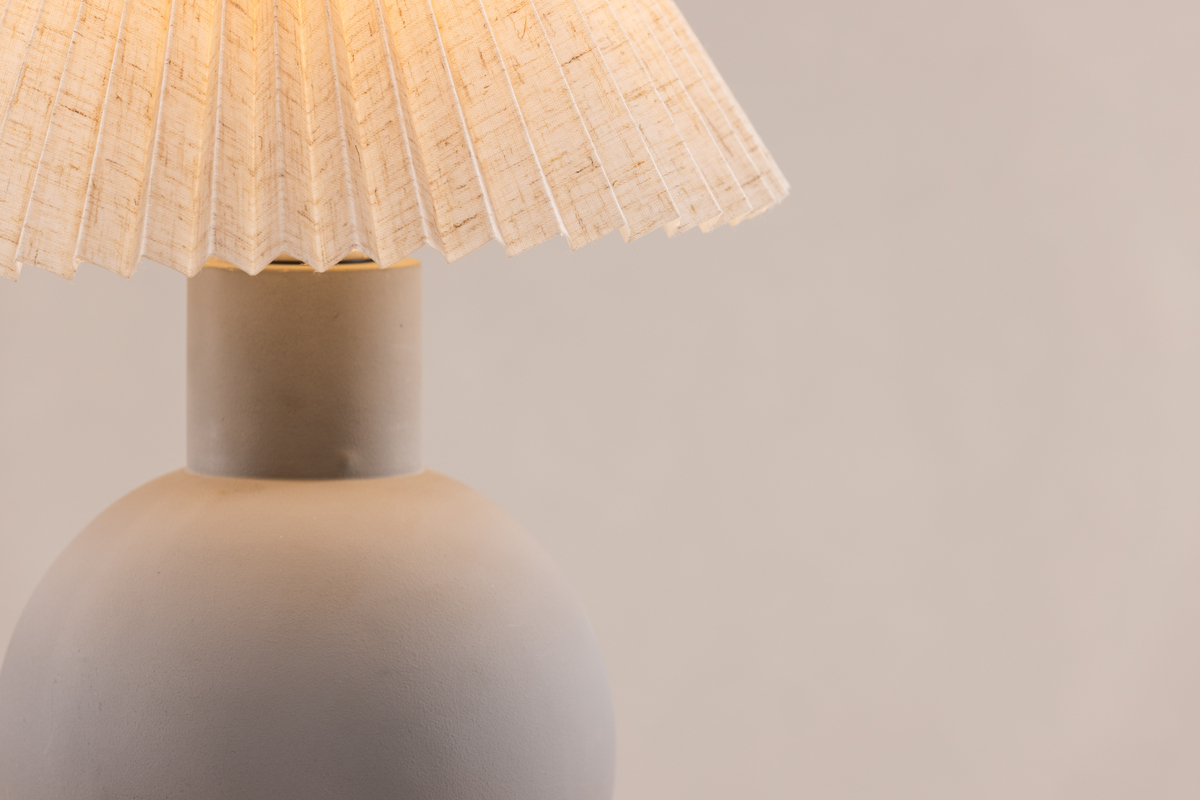 Älvsborg 37cm Gris lámpara de mesa De Venture Design - Hormig&oacute;n, que crea una expresi&oacute;n elegante y r&uacute;stica, y la pantalla de la l&aacute;mpara est&aacute; hecha de lino beige.