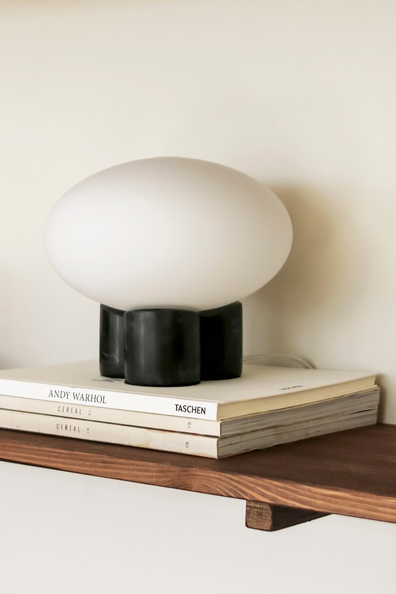 Mammut 18cm Negro lámpara de mesa De Globen Lighting - La base de la l&aacute;mpara est&aacute; equipada con una pantalla de cristal redonda, blanca mate y aplanada, de un tama&ntilde;o ligeramente sobredimensionado, que crea una expresi&oacute;n l&uacute;dica.