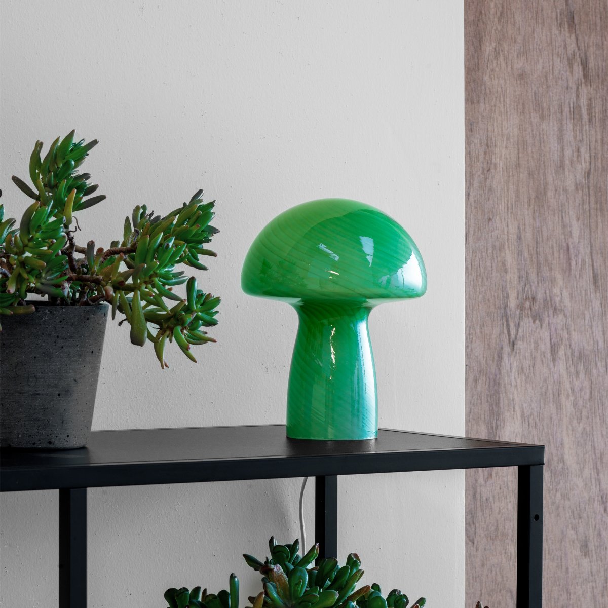 Jenny 23cm Verde lámpara de mesa De Dyberg Larsen - Ya sea colocada en una mesa auxiliar, en el alféizar de una ventana, en una mesita de noche o en un escritorio, la lámpara de mesa Jenny Mushroom es un accesorio perfecto que realzará su hogar con su encanto y elegancia.