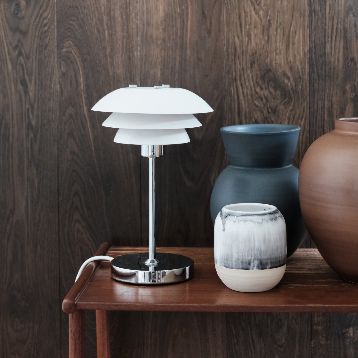 DL16 25cm Blanco lámpara de mesa De Dyberg Larsen - La lámpara de mesa DL16 es una lámpara elegante y compacta, perfecta para una estantería o una habitación pequeña.