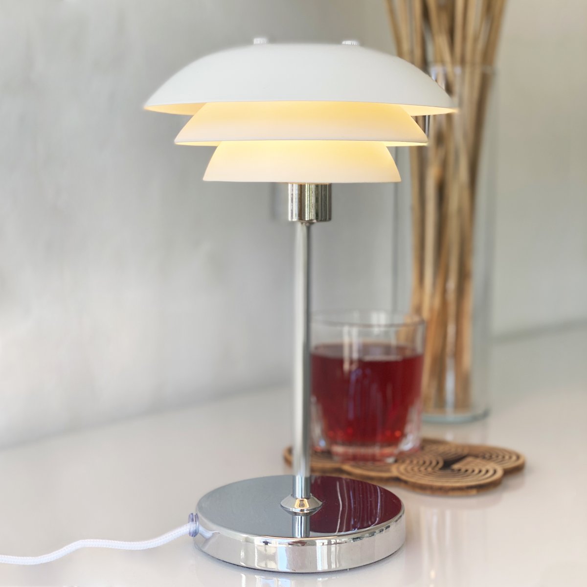 DL16 25cm Blanco lámpara de mesa De Dyberg Larsen - La lámpara de mesa DL16 es una lámpara elegante y compacta, perfecta para una estantería o una habitación pequeña.