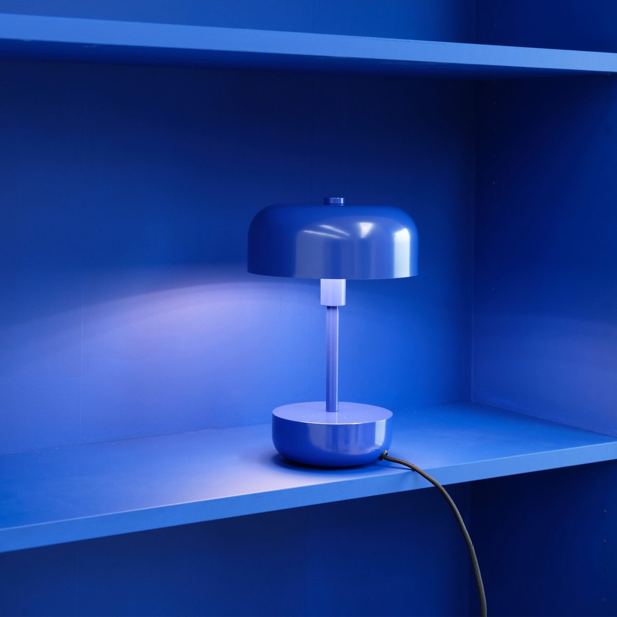 Haipot 25cm Azul lámpara de mesa De Dyberg Larsen - La pantalla abierta crea un hermoso efecto de luz que resalta el color de la base, creando una vista fascinante, especialmente al anochecer.
