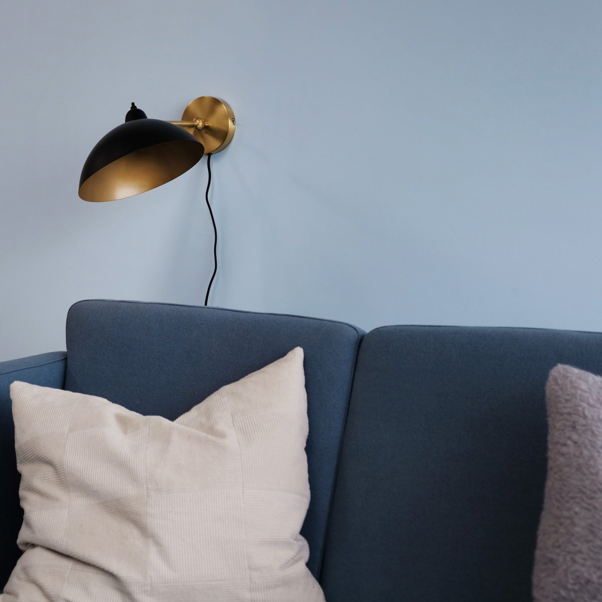 Futura 43cm Latón lámpara de pared De Dyberg Larsen - Está hecho de metal con un exterior negro y un interior de latón, lo que le da un aspecto elegante.