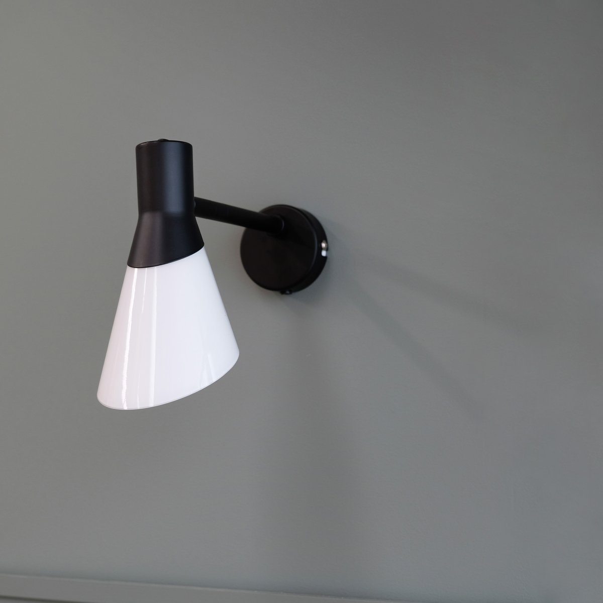 Gent 30cm Negro lámpara de pared De Dyberg Larsen - Gent es una lámpara de pared moderna y elegante con pantalla de cristal opalino combinado con metal negro.