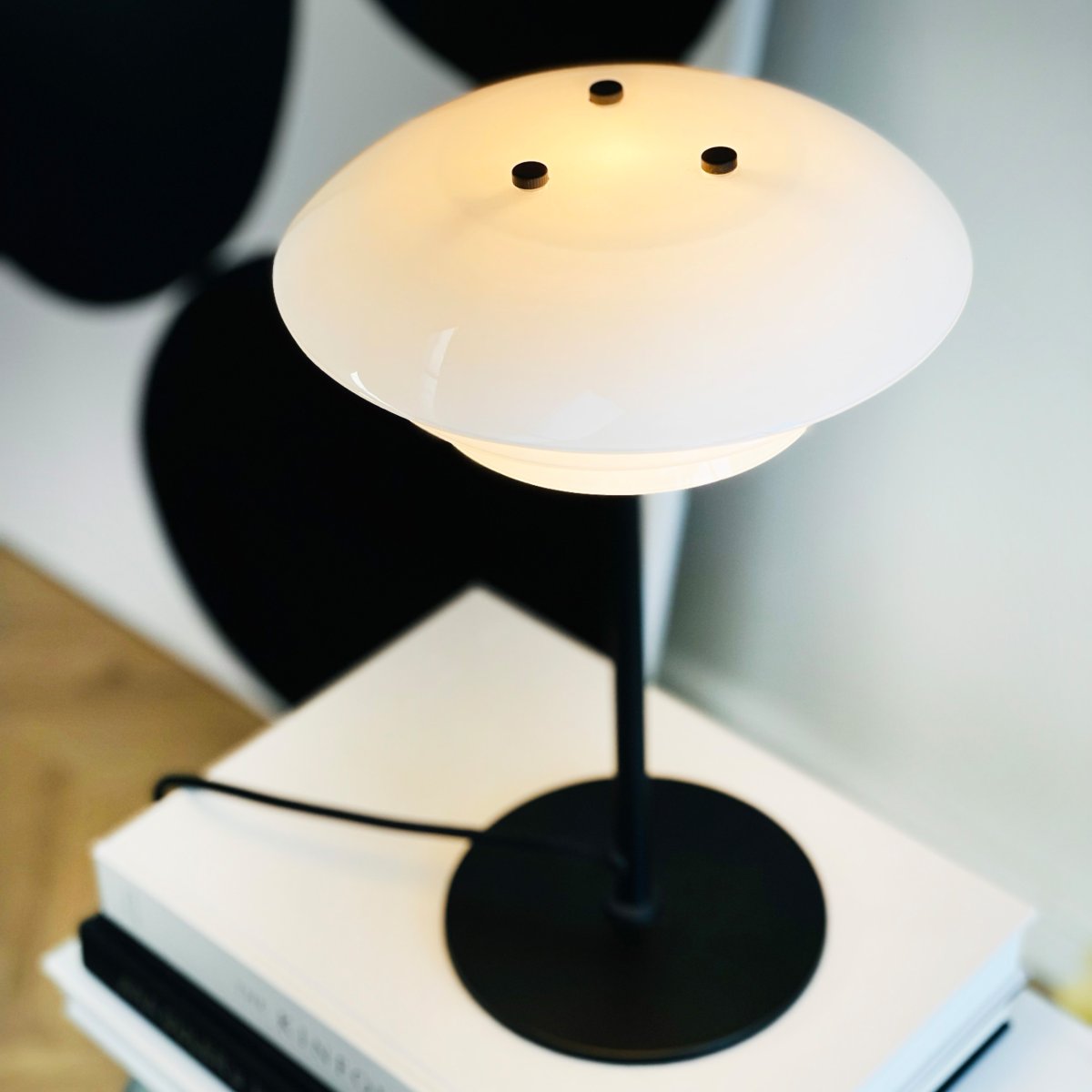 DL20 30cm Negro lámpara de mesa De Dyberg Larsen - La l&aacute;mpara de mesa DL20 en cristal opalino y color negro presenta un dise&ntilde;o exclusivo y lujoso que no s&oacute;lo es bello sino que adem&aacute;s proporciona una agradable iluminaci&oacute;n a la estancia, creando la atm&oacute;sfera perfecta para todas las ocasiones.