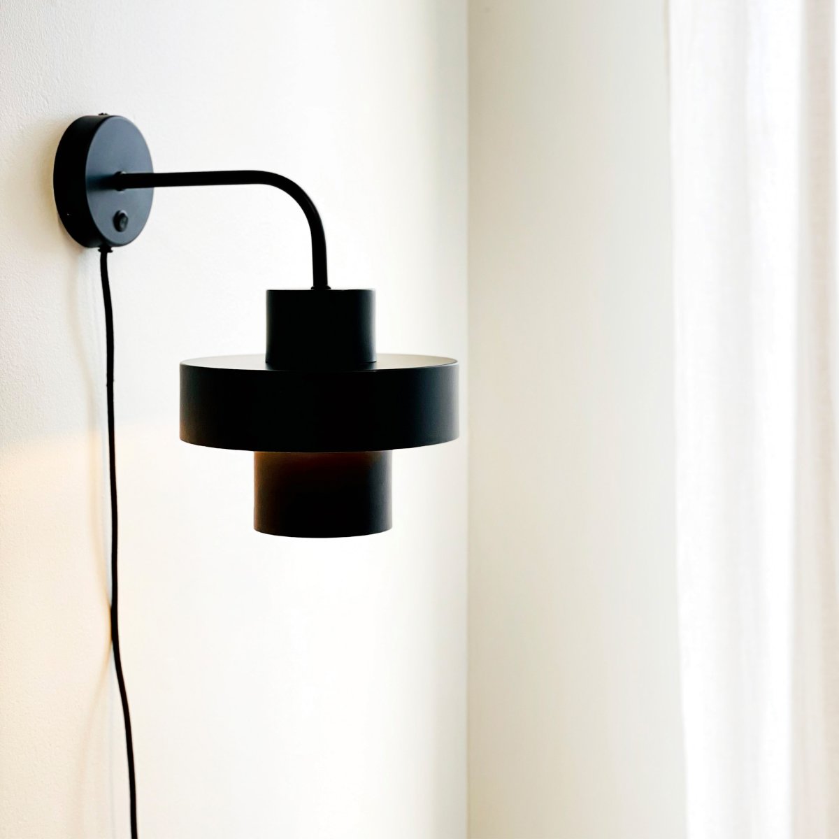 Stoke Ø15 Negro lámpara de pared De Dyberg Larsen - La lámpara funciona como un elegante detalle de decoración y como fuente de luz y tiene un interruptor de encendido en la base.