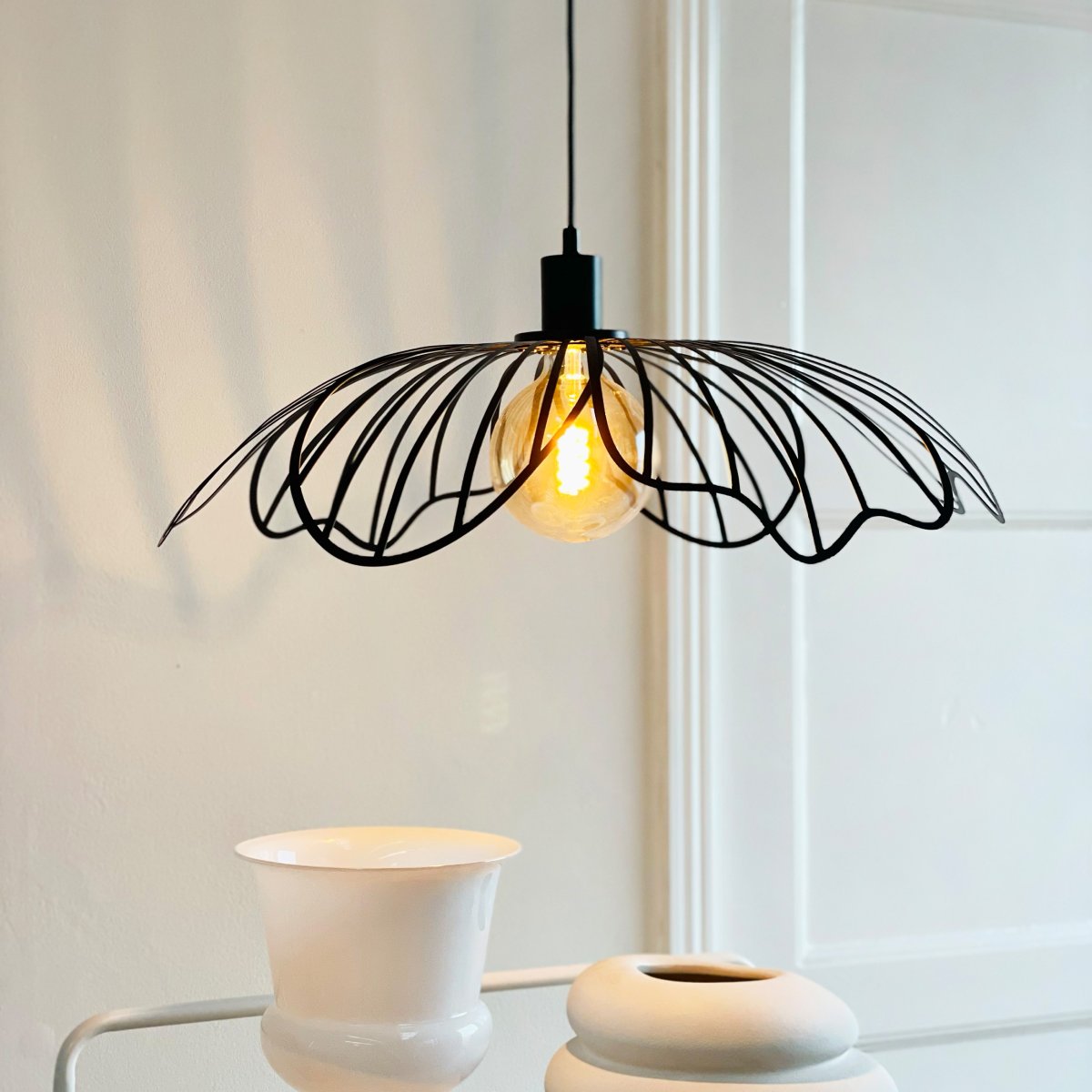 Blumen Ø60 Negro mate Lámpas de techo De Dyberg Larsen - Den sprider ett sofistikerat ljus och fungerar som en unik mittpunkt i hemmet, vare sig den h&auml;nger &ouml;ver matbordet, i vardagsrummet eller i entr&eacute;n.