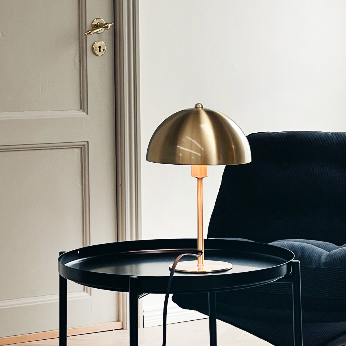 Lyon 30cm Latón lámpara de mesa De Dyberg Larsen - La pantalla semicircular añade un toque moderno y garantiza una distribución de la luz agradable y uniforme, ideal tanto para la iluminación de tareas como para la iluminación ambiental.