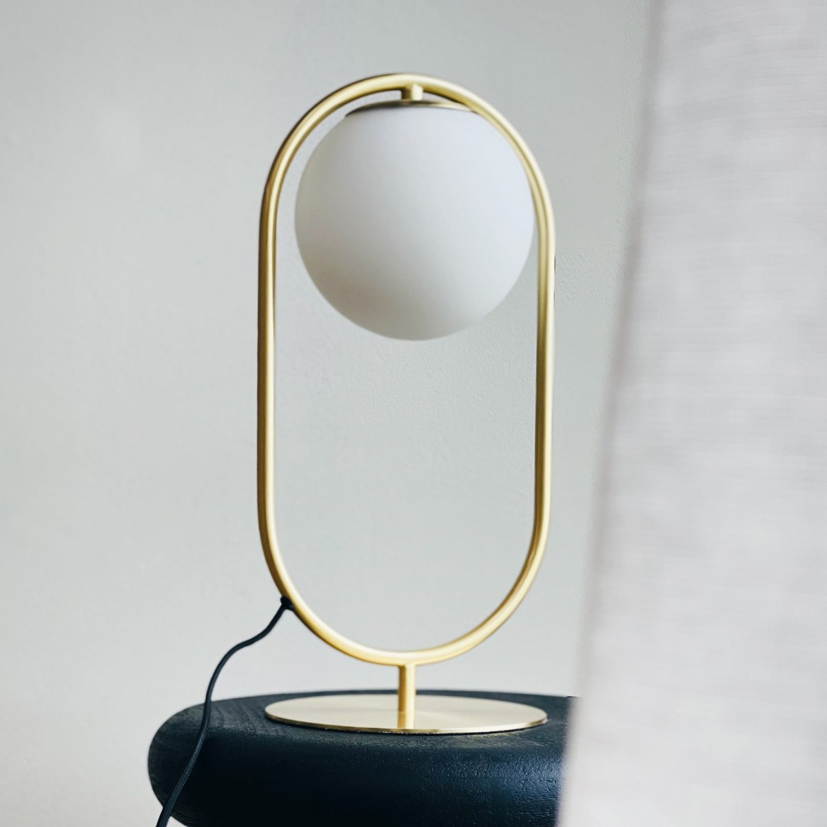Reims 40cm Latón/blanco lámpara de mesa De Dyberg Larsen - Con un cable de tela negro de 1,6 metros de largo y un cómodo interruptor de encendido y apagado, Reims es elegante y funcional.