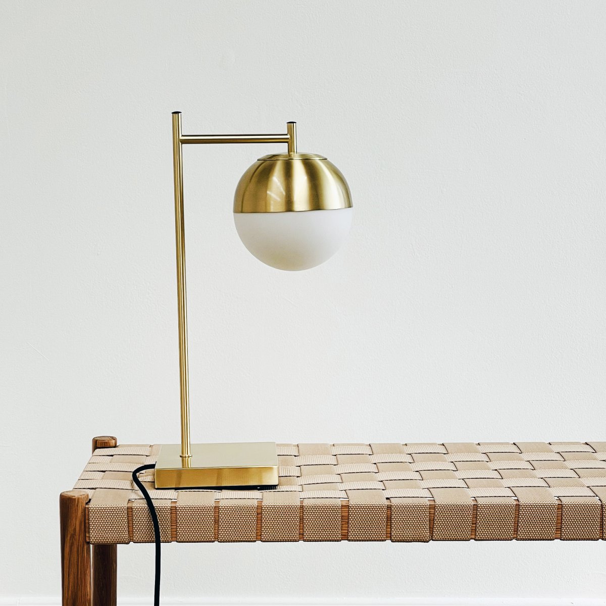 Caen 45cm Latón/blanco lámpara de mesa De Dyberg Larsen - La lámpara cuenta con un cable de tela negro de 1,6 metros de largo con un interruptor de encendido y apagado, lo que la hace elegante y funcional.